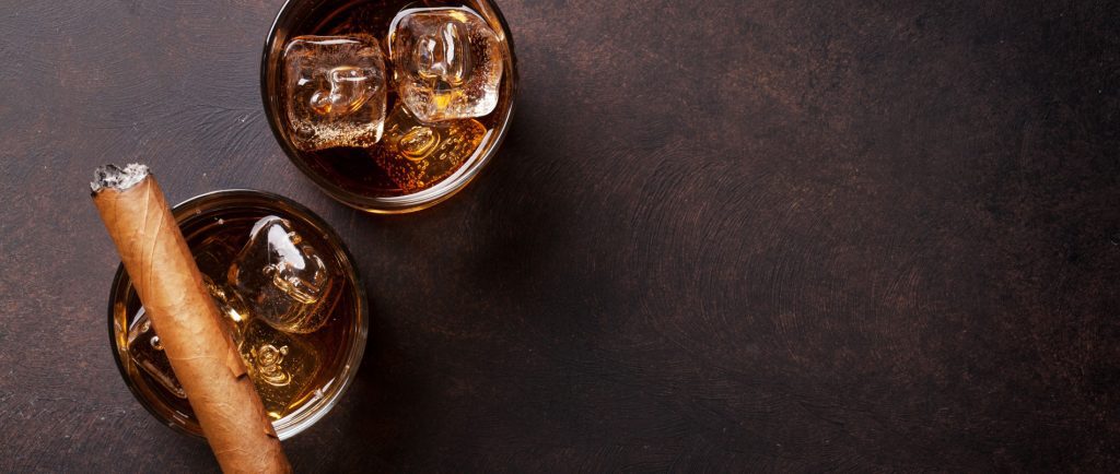 Two glasses of whiskey and a cigar