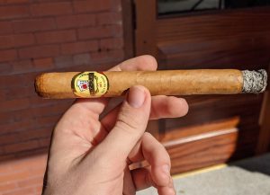 Hand holding a Baccarat Churchill lightly ashed at the end